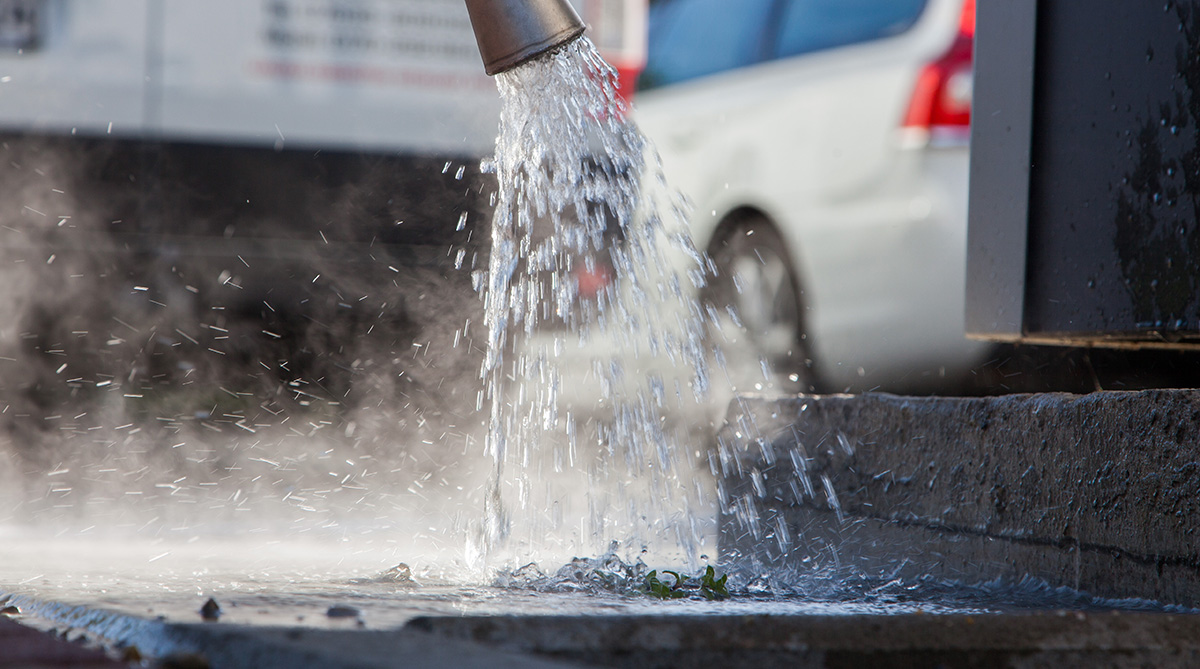 Heißes Wasser tropft aus einer Wasserlanze um Unkraut zu bekämpfen.